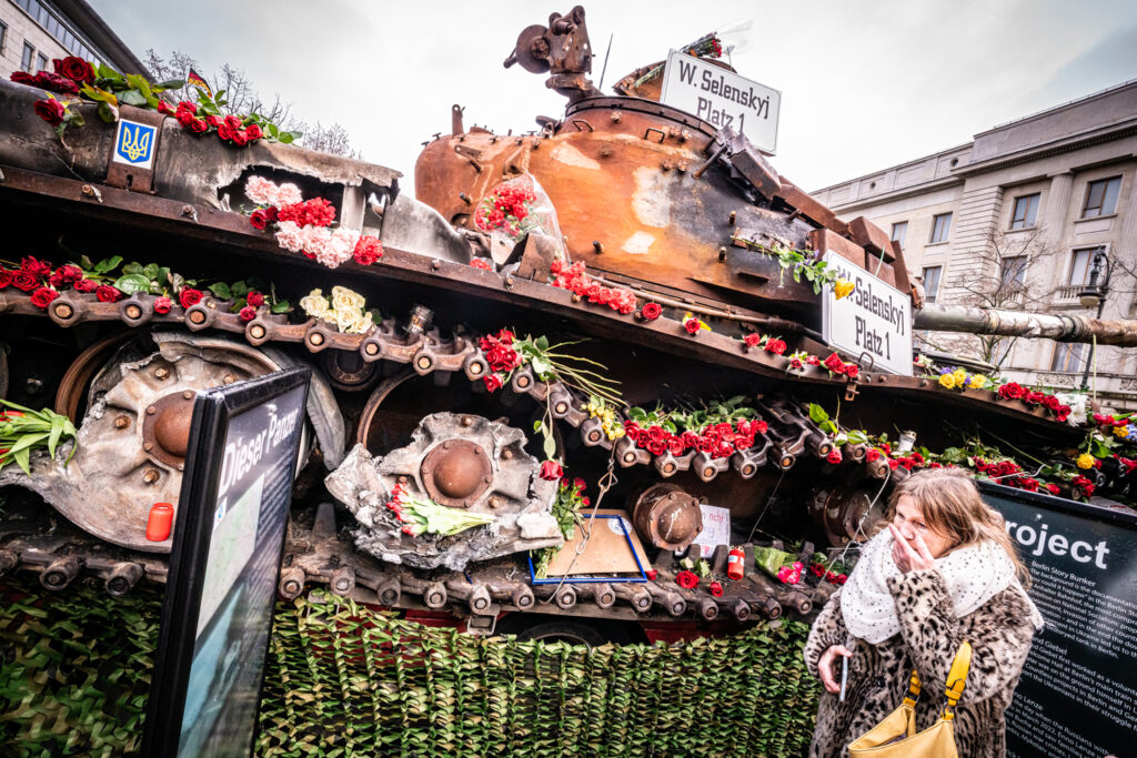 Europa, Deutschland, Berlin: Als Kunstaktion wurde ein ausgebombter russischer Panzer aus der Ukraine vor der russischen Botschaft in Berlin ausgestellt. Passanten haben viele Blumen, vor allem rote Rosen, auf dem Panzer abgelegt, viele machen Fotos und Selfies.

Eine Frau war offenbar sehr erschrocken ueber das, was sie auf den Tafeln las.

Europe, Germany, Berlin: As an art action, a bombed-out Russian tank from Ukraine was exhibited in front of the Russian embassy in Berlin. Passers-by have placed many flowers, especially red roses, on the tank, many take photos and selfies.